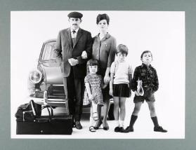 [Familie mit Kindern vor Auto stehend]
