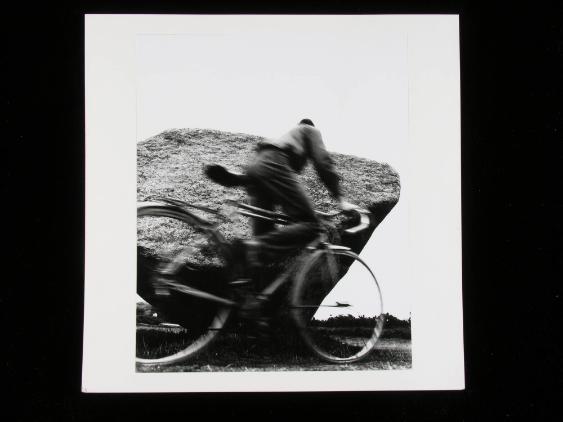 Velofahrer umkreist den umgestürzten Menhir