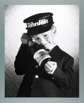 [Junge in Uniform mit Sektflasche]