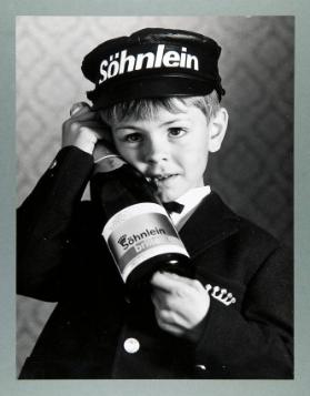 [Junge in Uniform mit Sektflasche]