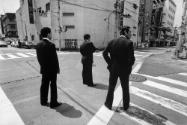 Alberto Venzago, Drei Mitglieder der Yakuza sichern eine Kreuzung, Tokio, Japan,1988 © Alberto …